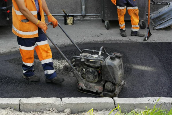 Plaka kompaktörler iasfalt döşeme. Asfalt döşenmesi, çukuru kaplaması, molozların üzerine.