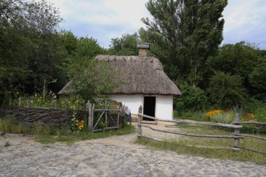 Eski Ukrayna evi. On dokuzuncu yüzyılın Ukrayna kulübesi. Yaz manzarası, güneş ışığı. Köy Pirogovo.
