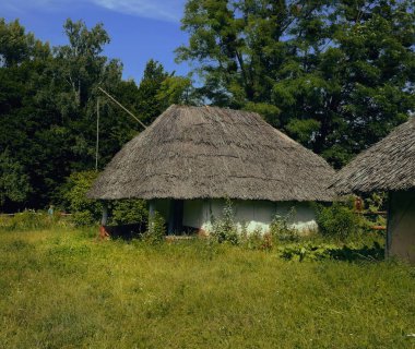 Eski Ukrayna evi. On dokuzuncu yüzyılın Ukrayna kulübesi. Yaz manzarası, güneş ışığı. Köy Pirogovo.