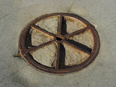 Yolda eski metal kapak.