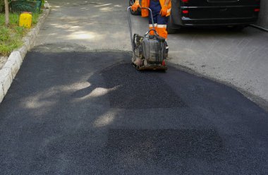 Plaka kompaktörler iasfalt döşeme. Asfalt döşenmesi, çukuru kaplaması, molozların üzerine.