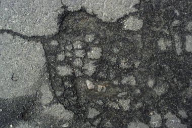 Kötü iş yapanlar. Asfalttaki delikler. Asfalt bir delik içinde su birikintisi.