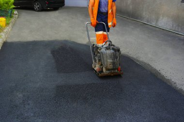 Plaka kompaktörler iasfalt döşeme. Asfalt döşenmesi, çukuru kaplaması, molozların üzerine.