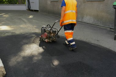 Plaka kompaktörler iasfalt döşeme. Asfalt döşenmesi, çukuru kaplaması, molozların üzerine.