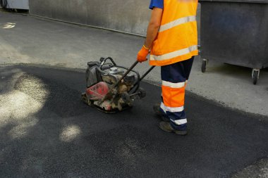 Plaka kompaktörler iasfalt döşeme. Asfalt döşenmesi, çukuru kaplaması, molozların üzerine.