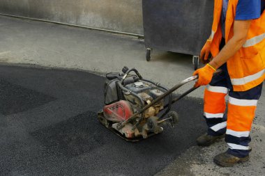 Plaka kompaktörler iasfalt döşeme. Asfalt döşenmesi, çukuru kaplaması, molozların üzerine.