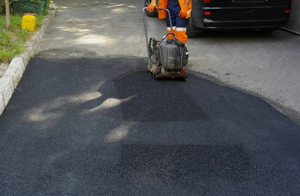 Plaka kompaktörler iasfalt döşeme. Asfalt döşenmesi, çukuru kaplaması, molozların üzerine.
