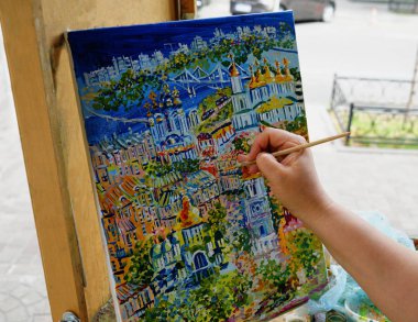                               Tuval üzerine resim. Fırçalı bir sanatçının eli resmi boyar..    