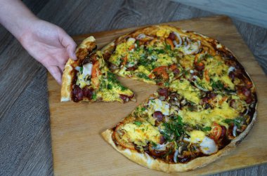 Fast food restoranındaki bir kız, diğer pizzalarla birlikte masanın önünden bir parça pizza alır. Seçici odaklama   