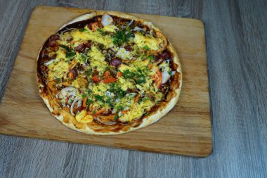 Mantar, sosis peyniri ve otlar ile Pizza, ahşap bir tahta üzerinde bir masada. Seçici odaklama   