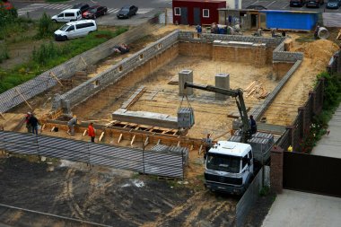 Bir hangar inşaatı, bir vinç manipülatör yardımıyla bir kamyondan köpük tuğla boşaltma. 08,10,2019 Kiev Ukrayna.       