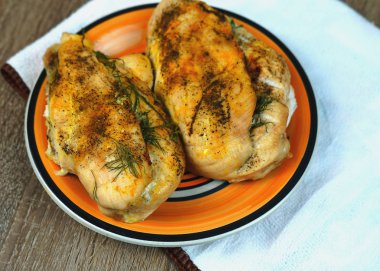   Tavuk fileto fırında pişmiş, bir çatal ve bıçak ile turuncu bir tabak üzerinde bir masada. opying alanı . seçici odaklama .