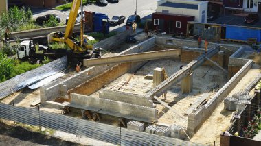 Bir vinç ve inşaatçılar yardımıyla evin inşaatı sırasında beton kiriş montajı.08,20,2019 Kiev Ukrayna.