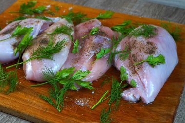    Karabiber baharat ve maydanoz ve dereotu yeşillik ile kahverengi ahşap mutfak tahtası üzerinde Çiğ tavuk eti.   