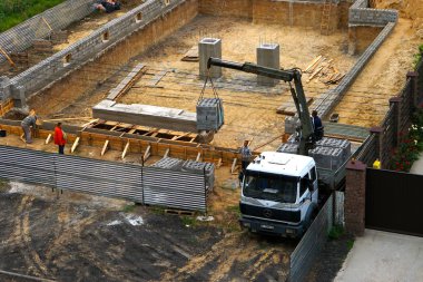   Bir hangar inşaatı, bir vinç manipülatör yardımıyla bir kamyondan köpük tuğla boşaltma. 08,10,2019 Kiev Ukrayna.     