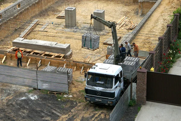   Bir hangar inşaatı, bir vinç manipülatör yardımıyla bir kamyondan köpük tuğla boşaltma. 08,10,2019 Kiev Ukrayna.     