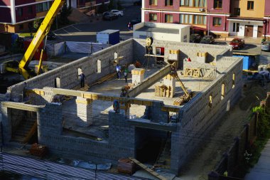  Bir vinç ve inşaatçılar yardımıyla evin inşaatı sırasında beton kiriş montajı. 08,20,2019 Kiev Ukrayna.   