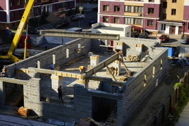  Bir vinç ve inşaatçılar yardımıyla evin inşaatı sırasında beton kiriş montajı. 08,20,2019 Kiev Ukrayna.   