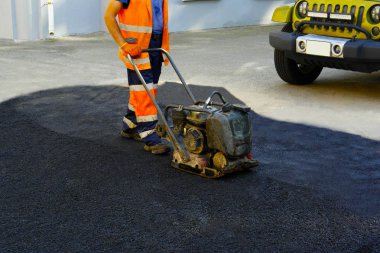 Plaka kompaktörler iasfalt döşeme. Asfalt döşenmesi, çukurun üzerini kaplayan, molozların üzerine.seçici odak 