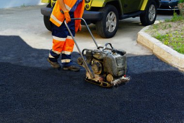 Plaka kompaktörler iasfalt döşeme. Asfalt döşenmesi, çukurun üzerini kaplayan, molozların üzerine.seçici odak 