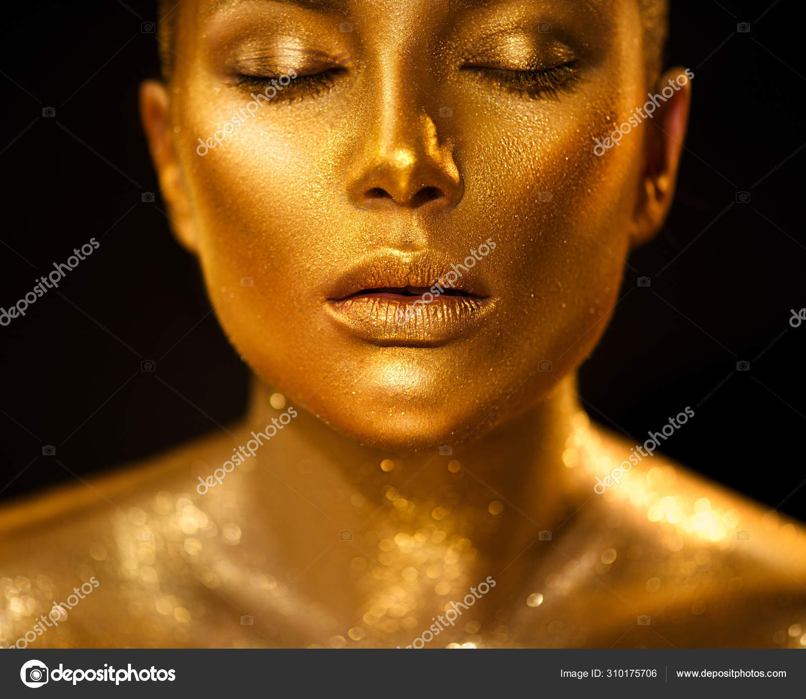 Model girl with bright golden sparkles on her body posing, full