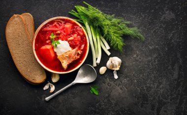 Geleneksel Ukrayna Rus borscht. Siyah rustik masada kırmızı pancar kökü çorba borsch tabak. Pancar çorbası üst görünümü. Geleneksel Ukrayna mutfağı