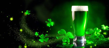 Aziz Patrick Günü. Shamrock yaprakları ile dekore koyu yeşil arka plan üzerinde yeşil bira pint. Geleneksel İrlanda festivali