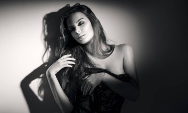 Seksi genç kadın siyah beyaz portre. Uzun saçlı baştan çıkarıcı genç kadın spot poz