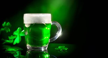Aziz Patrick Günü. Shamrock yaprakları ile dekore koyu yeşil arka plan üzerinde yeşil bira pint. Geleneksel İrlanda festivali
