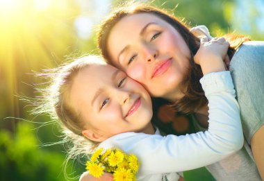 Mutlu anne ve küçük kızı dışarıda. Anne ve kızı yeşil parkta birlikte doğanın tadını çıkarıyorlar. Anneler Günü konsepti