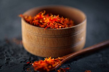 Safran. Siyah taş masa üzerinde ahşap kase Hint baharatlar. Spic