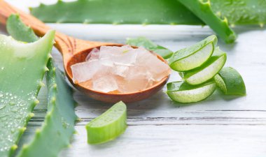 Aloe Vera jel yakın çekim. Dilimlenmiş Aloevera doğal organik yenileme kozmetik, alternatif tıp. Organik cilt bakımı konsepti. Beyaz ahşap arka plan üzerinde