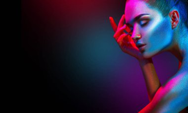 Renkli parlak ışıltılar ve stüdyoda poz neon ışıklar moda model kadın. Sanat tasarımı renkli canlı makyaj.