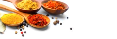 Baharat. Beyaz arka plan üzerinde ahşap kaşık çeşitli baharatlar. Köri, safran, zerdeçal, tarçın