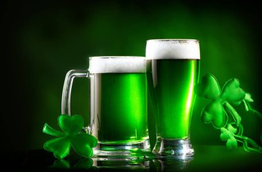 Aziz Patrick Günü. Shamrock yaprakları ile dekore koyu yeşil arka plan üzerinde yeşil bira pint. Geleneksel İrlanda festivali