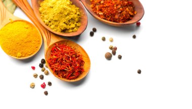 Baharat. Beyaz arka plan üzerinde ahşap kaşık çeşitli baharatlar. Köri, safran, zerdeçal, tarçın