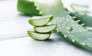 Aloe Vera yakın çekim. Dilimlenmiş Aloevera doğal organik yenileme kozmetik, alternatif tıp. Organik cilt bakımı konsepti. Beyaz ahşap arka plan üzerinde