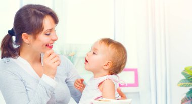 Anne küçük kızını kaşıkla besliyor. Bebek maması. Sağlıklı fa