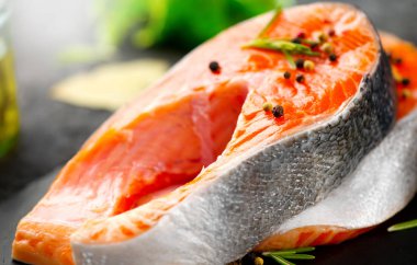 Somon. Siyah kayrak backgroun otlar ile Çiğ alabalık balık biftek