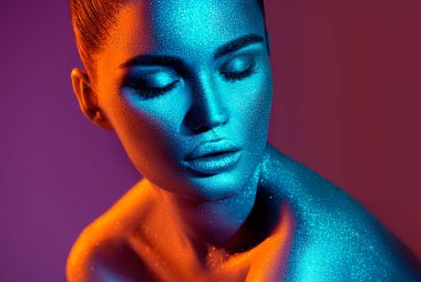 Renkli parlak ışıltılar ve stüdyoda poz neon ışıklar moda model kadın. Sanat tasarımı renkli canlı makyaj.
