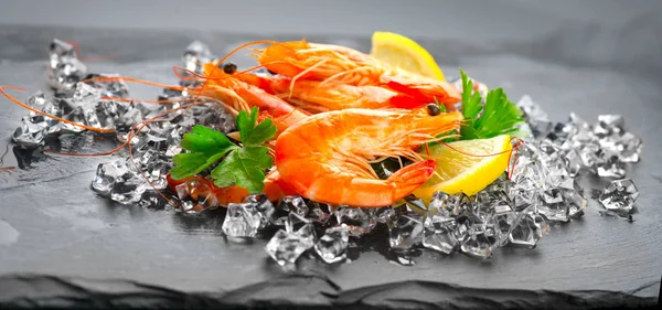 Camarões. Camarão fresco sobre fundo preto. Frutos do mar em caiu — Fotografia de Stock