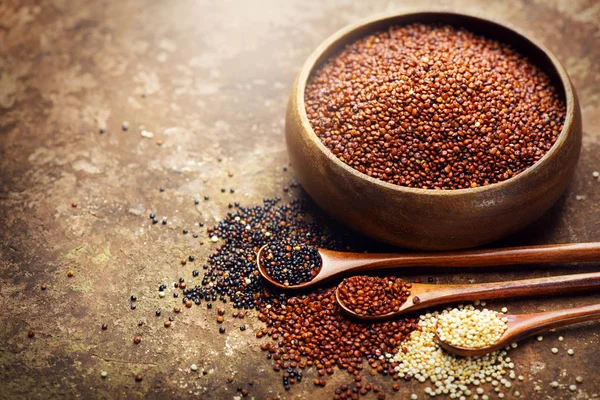 Quinoa. Červená, černá a bílá chinozrnná zrna v dřevěné misce. HEA — Stock fotografie