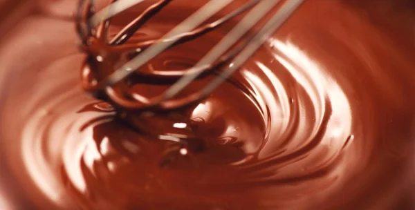 Schokolade. Mischen geschmolzene dunkle Schokolade mit einem Schneebesen. Nahaufnahme — Stockfoto