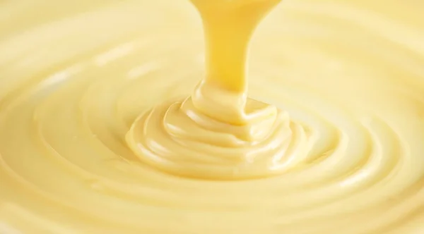 White chocolate. Pouring melted liquid white chocolate. Closeup — Stock Photo, Image
