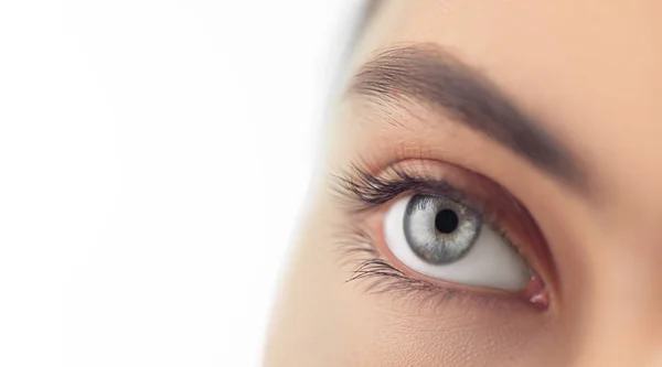 Młoda kobieta zbliżenie niebieskie oko. Makro oko patrząc w górę, izolowane na — Zdjęcie stockowe