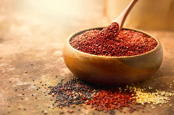 Quinoa. Červená, černá a bílá chinozrnná zrna v dřevěné misce. HEA — Stock fotografie
