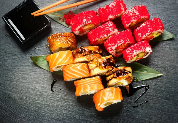 Sushi com pauzinhos e molho de soja. Sushi roll comida japonesa em — Fotografia de Stock