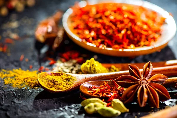 Especiarias. Várias especiarias indianas na mesa de pedra preta. Spice e ele — Fotografia de Stock