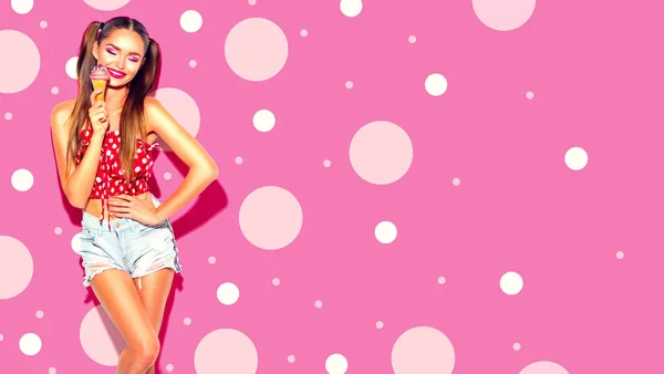 美しさ楽しいセクシーなモデルの女の子が笑顔 ダンスとアイスクリームコーンでポーズ ピンクの背景にアイスクリームを持つ若い女性 — ストック写真