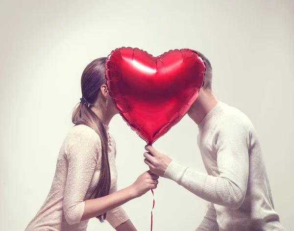 バレンタインデーだハート型の気球とキスを持つ幸せな喜びのカップル — ストック写真
